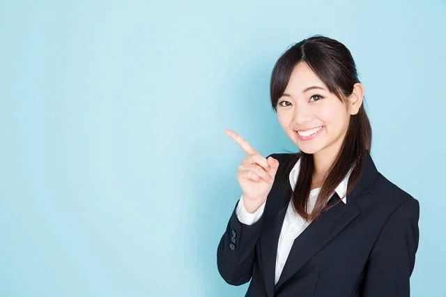 指をさす紺スーツ女性